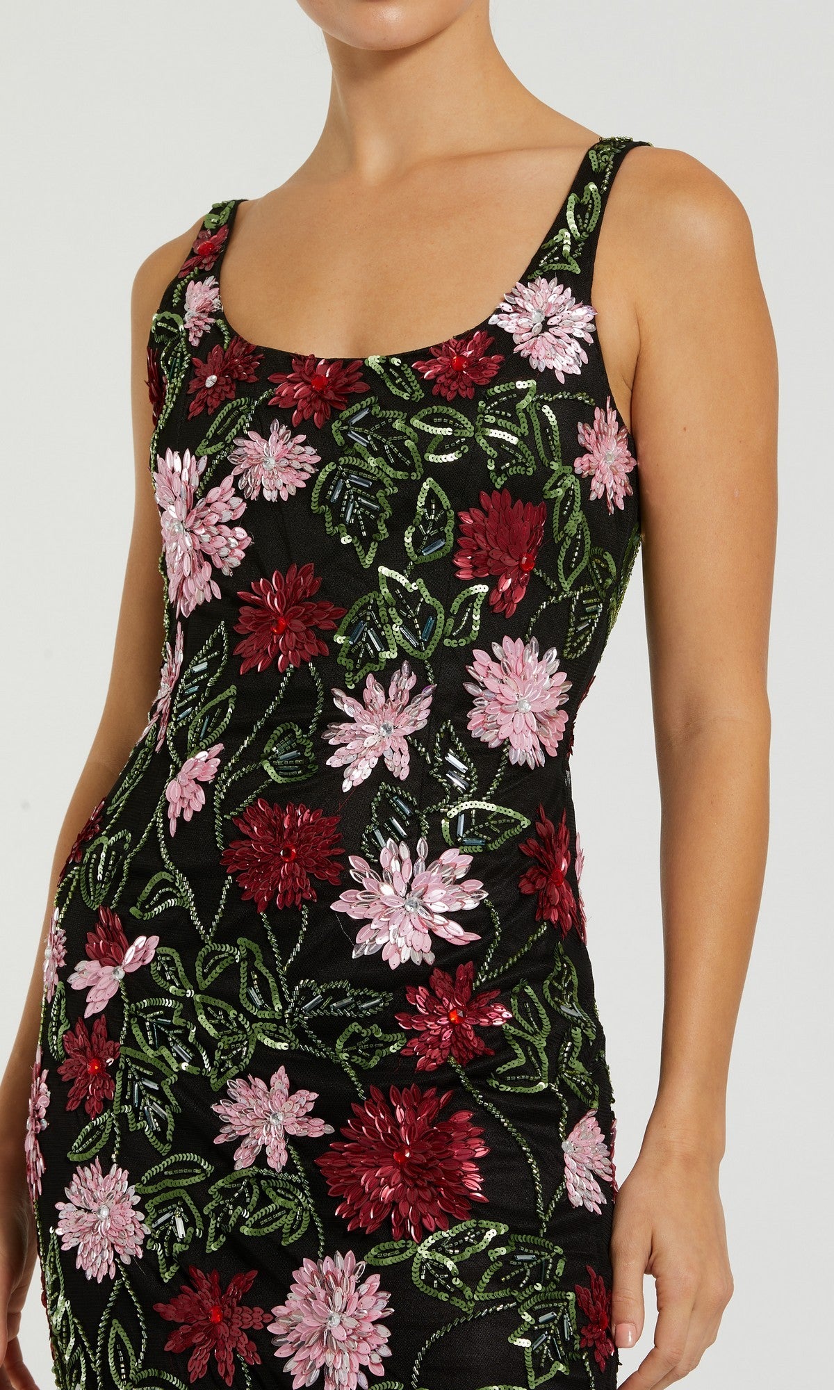 A woman wearing the Mac Duggal 6124 Beaded Midi Wedding Guest Dress, a sleeveless black dress with red and pink floral beading and green leaf embroidery.